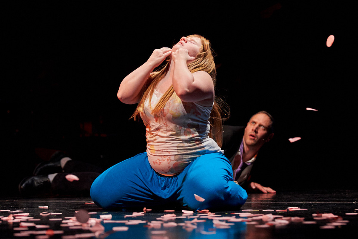 Schauspielerin Julia Häusermann kniet auf der Bühne und schaut nach oben. Dahinter kriecht Felix Loycke auf dem Boden und schaut überrascht. Foto: Holger Rudolph